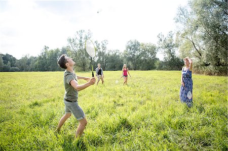 simsearch:649-08328214,k - Group of young adults playing badminton in field Foto de stock - Royalty Free Premium, Número: 649-08328222