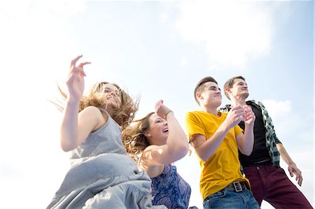 simsearch:649-08328214,k - Group of young adults, running, outdoors, low angle view Foto de stock - Royalty Free Premium, Número: 649-08328232