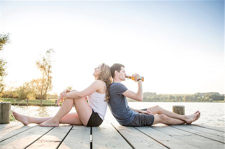 Young couple relaxing on jetty, sitting back to back Stock Photo - Premium Royalty-Free, Code: 649-08328268
