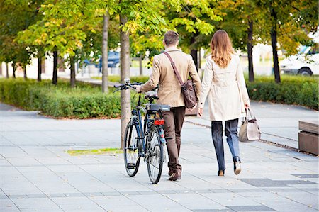 Casual businessman and woman pushing bike Stock Photo - Premium Royalty-Free, Code: 649-08328574