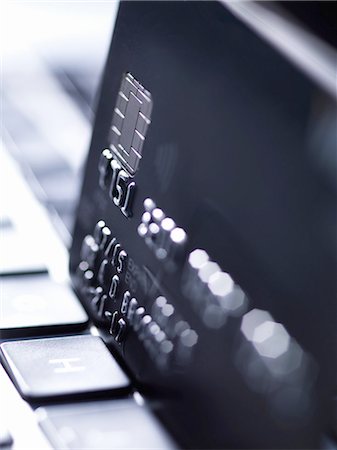 Close up of black credit card standing on computer keyboard Photographie de stock - Premium Libres de Droits, Code: 649-08328626