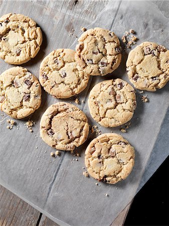 simsearch:649-07280922,k - Overhead view of chocolate chunk cookies on greaseproof paper Photographie de stock - Premium Libres de Droits, Code: 649-08328662