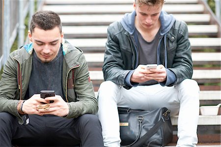 step (action, stepping on something) - Two young men, sitting on steps, using smartphones, outdoors Stock Photo - Premium Royalty-Free, Code: 649-08328769