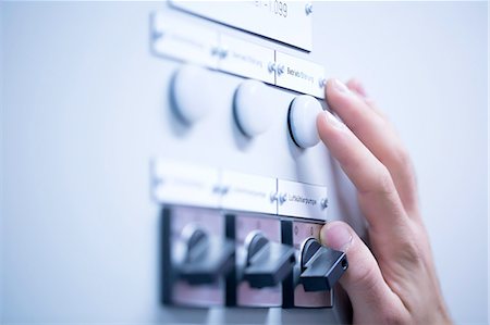 Cropped view of young mans hand adjusting dial on switchgear Stock Photo - Premium Royalty-Free, Code: 649-08328783