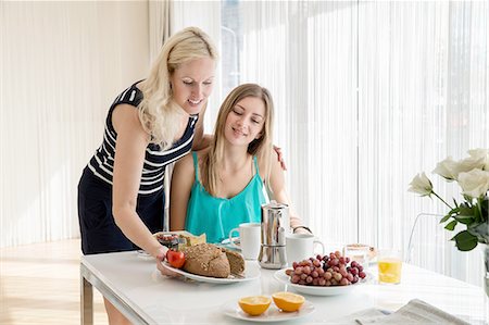 Woman serving friend continental breakfast Stock Photo - Premium Royalty-Free, Code: 649-08328805