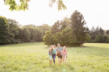 simsearch:649-08381348,k - Front view of family carrying picnic blanket walking on field landscape Fotografie stock - Premium Royalty-Free, Codice: 649-08328842