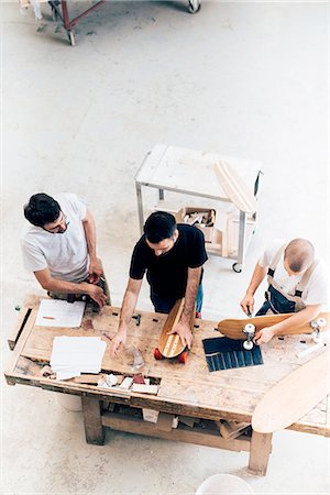 simsearch:649-08329135,k - Men working on skateboards in workshop Foto de stock - Royalty Free Premium, Número: 649-08329153