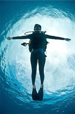 simsearch:614-08383630,k - Full length front view of scuba diver arms open floating near water surface looking at camera, Chinchorro Atoll, Quintana Roo, Mexico Photographie de stock - Premium Libres de Droits, Code: 649-08381039