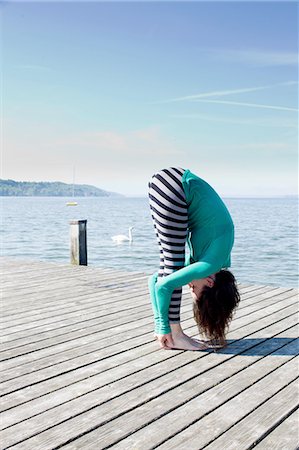 stretch outdoors - Side view of mature woman on pier by ocean bending over holding ankles Stock Photo - Premium Royalty-Free, Code: 649-08381060