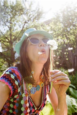 sunglasses happy white - Mature woman wearing sunhat and sunglasses blowing dandelion seeds Stock Photo - Premium Royalty-Free, Code: 649-08381070