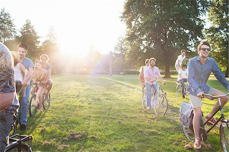 simsearch:614-08926241,k - Rows of party going adults arriving in park on bicycles at sunset Stock Photo - Premium Royalty-Free, Code: 649-08381072