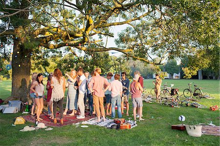 plastikbecher - Crowd of adults under a tree at sunset party in park Stockbilder - Premium RF Lizenzfrei, Bildnummer: 649-08381084