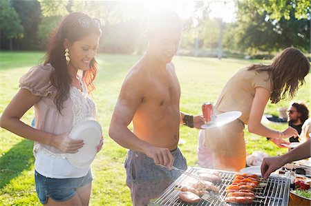 pictures of a party where people eating food - Group of friends barbecuing at sunset park party Stock Photo - Premium Royalty-Free, Code: 649-08381109