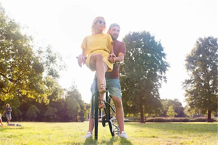 simsearch:614-08544737,k - Young couple on bicycle at sunset party in park Photographie de stock - Premium Libres de Droits, Code: 649-08381101