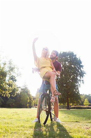 Young couple on bicycle taking smartphone selfie in sunlit park Foto de stock - Sin royalties Premium, Código: 649-08381102