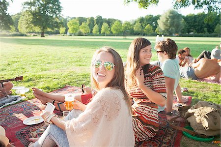 Happy young woman and friends at sunset park party Photographie de stock - Premium Libres de Droits, Code: 649-08381162