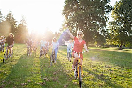 Group of partygoing adults arriving on cycles to sunset park party Stock Photo - Premium Royalty-Free, Code: 649-08381172