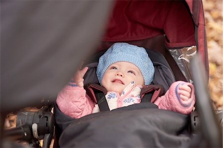 simsearch:614-09253640,k - Baby girl wearing blue hat looking up from baby carriage Foto de stock - Sin royalties Premium, Código: 649-08381273