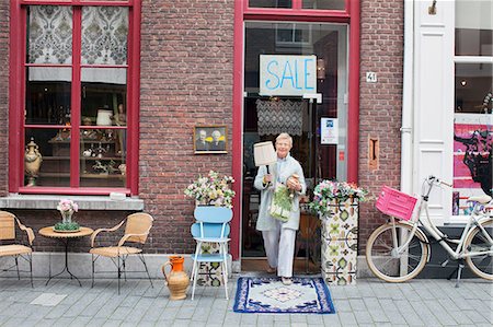 simsearch:649-08381297,k - Mature female customer carrying lamp outside vintage shop Stock Photo - Premium Royalty-Free, Code: 649-08381293