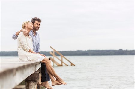 simsearch:649-08577001,k - Mature couple sitting on edge of pier, relaxing Fotografie stock - Premium Royalty-Free, Codice: 649-08381574