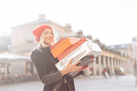 Portrait of stylish young woman carrying stack of christmas gifts, Covent Garden, London, UK Photographie de stock - Premium Libres de Droits, Code: 649-08381637