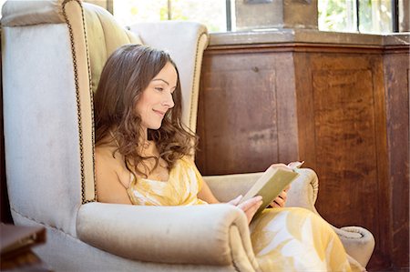 Woman reading book in old armchair at Thornbury Castle, South Gloucestershire, UK Stock Photo - Premium Royalty-Free, Code: 649-08381742