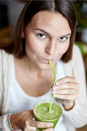 drinking straw not child - Woman drinking green smoothie with straw Stock Photo - Premium Royalty-Free, Code: 649-08422491