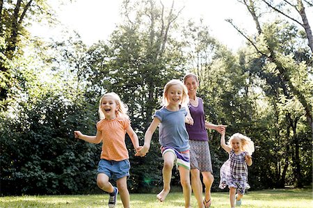 simsearch:649-08422542,k - Mid adult woman and three young daughters running in park Stock Photo - Premium Royalty-Free, Code: 649-08422517