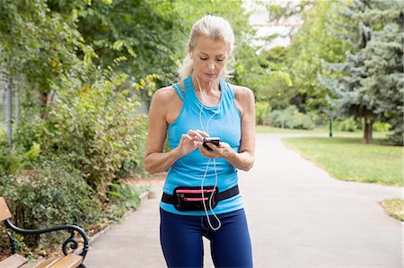 simsearch:649-07710284,k - Mature woman choosing smartphone music whilst training in park Stock Photo - Premium Royalty-Free, Code: 649-08422569