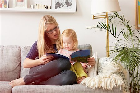 Mid adult woman and toddler daughter reading on sofa Foto de stock - Sin royalties Premium, Código: 649-08422588