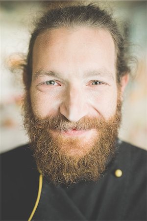 Portrait of bearded mid adult man looking at camera smiling Stock Photo - Premium Royalty-Free, Code: 649-08422672