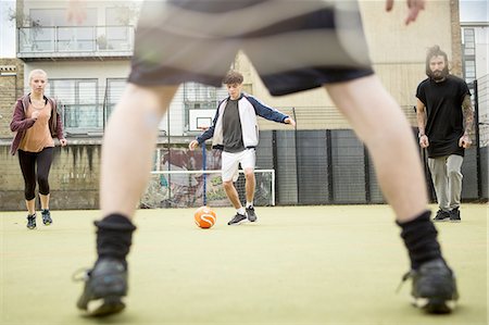 simsearch:6122-07697777,k - Group of adults playing football on urban football pitch Photographie de stock - Premium Libres de Droits, Code: 649-08422756