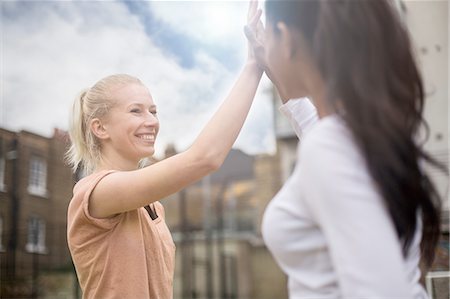 Two young women giving high five, outdoors Fotografie stock - Premium Royalty-Free, Codice: 649-08422779