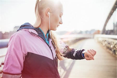 running women pictures - Mid adult female runner checking time on footbridge Stock Photo - Premium Royalty-Free, Code: 649-08422865