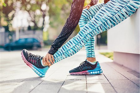 Cropped shot of female runner stretching legs on sidewalk Stock Photo - Premium Royalty-Free, Code: 649-08422863