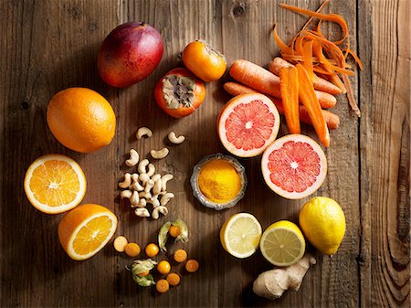 dietary supplement - Overhead view of orange fruit and vegetables on wood grain pattern background Stock Photo - Premium Royalty-Free, Code: 649-08422904