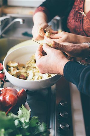 people and food close up - Male and female hands slicing globe artichokes in kitchen Stock Photo - Premium Royalty-Free, Code: 649-08422921