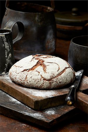 Fresh baked organic bread, Pain de Campagne Rond, on chopping board Stock Photo - Premium Royalty-Free, Code: 649-08423046