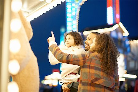 people night illuminated outdoors - Young family enjoying funfair Stock Photo - Premium Royalty-Free, Code: 649-08423096