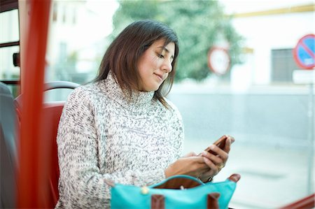 simsearch:6111-06838105,k - Mature woman sitting on bus, looking at smartphone Foto de stock - Sin royalties Premium, Código: 649-08423102