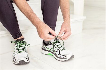 Cropped shot of senior mans hands tying trainer laces  on staircase Foto de stock - Sin royalties Premium, Código: 649-08423210