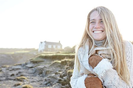 Happy young woman wrapping up in scarf at beach, Constantine Bay, Cornwall, UK Stock Photo - Premium Royalty-Free, Code: 649-08423222