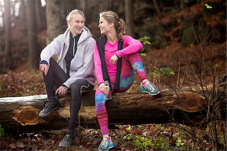 Full length view of couple wearing sports clothing sitting on fallen tree, smiling Stock Photo - Premium Royalty-Free, Code: 649-08423332