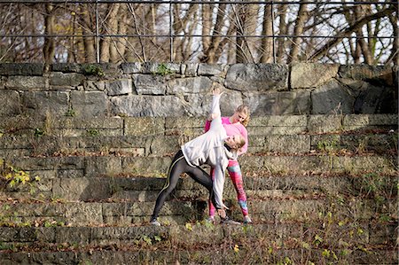 simsearch:649-08423361,k - Full length front view of mid adult man on stone steps bending over, arm raised stretching Stock Photo - Premium Royalty-Free, Code: 649-08423357