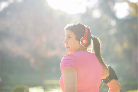 Rear view of mature woman wearing headphones and armband looking away Stock Photo - Premium Royalty-Free, Code: 649-08423403