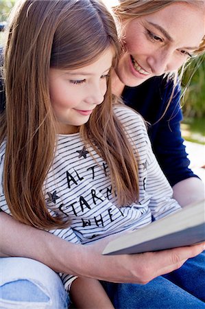 parent reading child - Mother and daughter reading book together, smiling Foto de stock - Sin royalties Premium, Código: 649-08479468