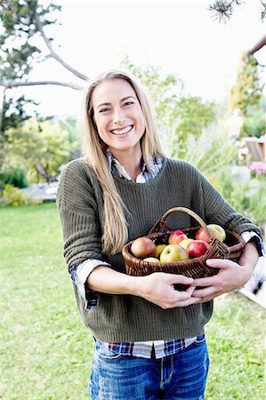 Mid adult woman holding basket of apples, portrait Stock Photo - Premium Royalty-Free, Code: 649-08479478