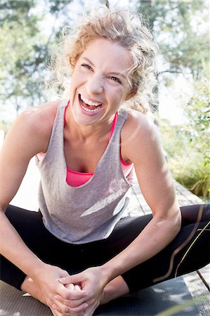 Young woman in sports clothes sitting on floor, laughing Stock Photo - Premium Royalty-Free, Code: 649-08479470
