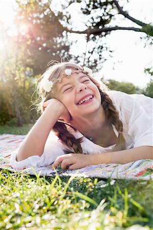 Girl with flowers round head laughing with eyes closed Stock Photo - Premium Royalty-Free, Code: 649-08479528