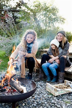 firepit and outdoors - Two women and girl sitting by fire pit, relaxing Stock Photo - Premium Royalty-Free, Code: 649-08479535